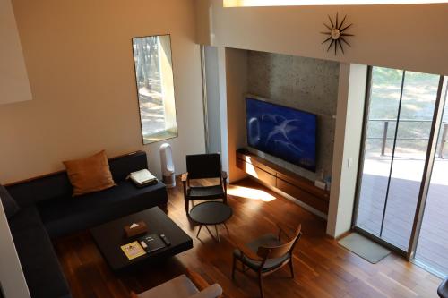 a living room with a couch and a tv at Lohas Resort Fukae in Itoshima