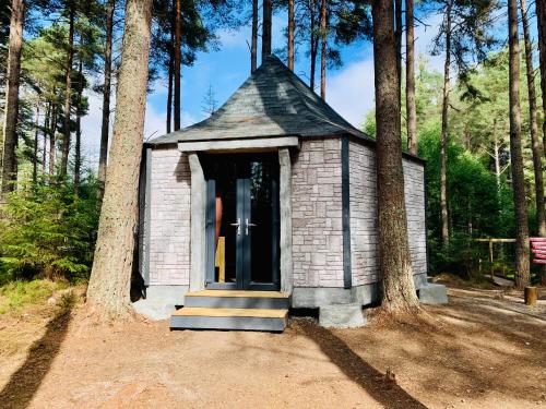 a small house in the middle of some trees at Hagrids Hut - Off grid Cabin - no electricity or running water in Munlochy