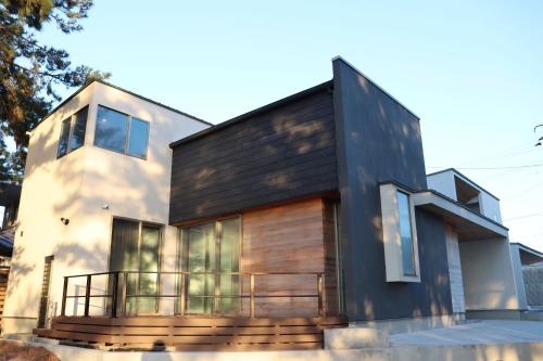 a house with a black and wooden facade at Lohas Resort Fukae in Itoshima
