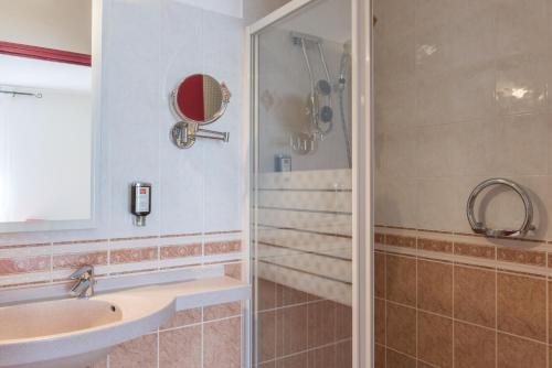 a bathroom with a sink and a shower at Hotel Bristol in Chalons en Champagne