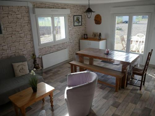 uma sala de estar com uma mesa de jantar e um sofá em Les Loges Farm em Le Breuil-sous-Argenton