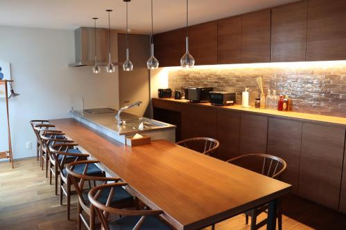 a kitchen with a long wooden table and chairs at Lohas Resort Fukae in Itoshima