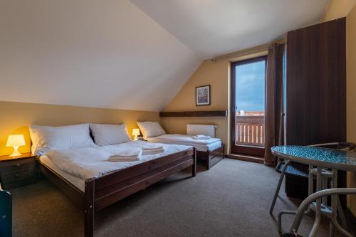 a bedroom with two beds and a large window at Villa Vesperia in Ižipovce