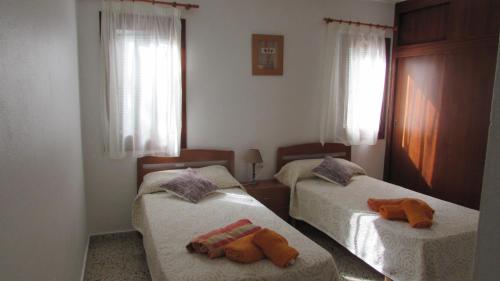 een slaapkamer met twee bedden met knuffels erop bij Villa en Sa Roca in Es Mercadal
