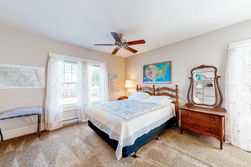a bedroom with a bed and a mirror and a fan at The Whole Fam-Damily in Hebron