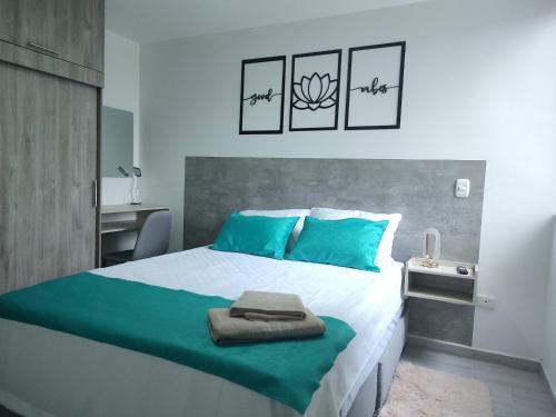 1 dormitorio con 1 cama grande con almohadas azules en GURUS FR | Elegante Apartamento en parque acuático Dosquebradas, en Dosquebradas