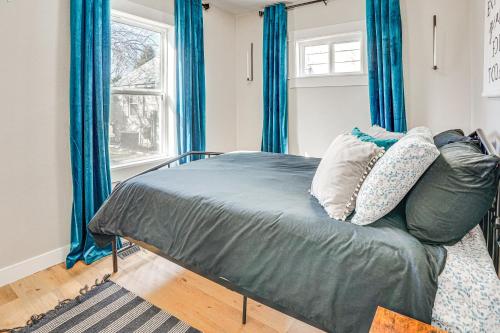 1 dormitorio con 1 cama con cortinas azules en Pet-Friendly Watertown Home about 1 Mi to Downtown! en Watertown