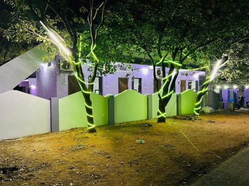two trees in front of a fence at night at Hotel R residence in Srīsailam