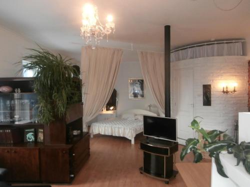 a bedroom with a bed and a chandelier at Private Apartment For You in Tartu