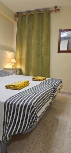 uma cama com um cobertor preto e branco e uma janela em Apartamento en la playa Salou em Salou