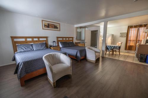 1 dormitorio con 1 cama y sala de estar en Motel Deblois, en Sainte-Anne-de-Beaupré