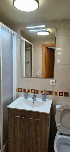 a bathroom with a sink and a toilet and a mirror at Apartamento en la playa Salou in Salou