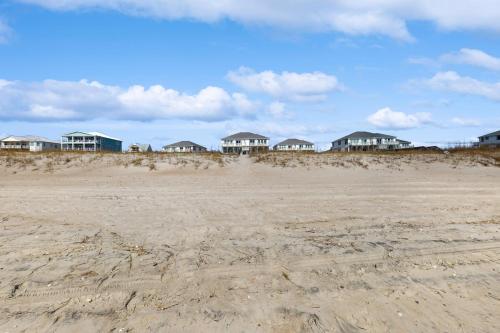 a row of houses on a sandy beach at Relax to the Max in Emerald Isle