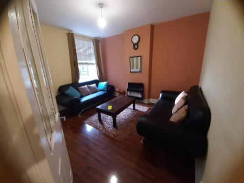 uma sala de estar com dois sofás e uma mesa em 4 Bedroom Holiday House in lenton em Nottingham