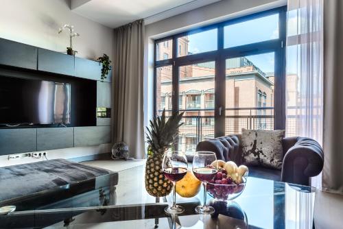 a living room with a table with glasses of wine at Lumina I Comfy Loft with Parking I View of the Lake in Łódź