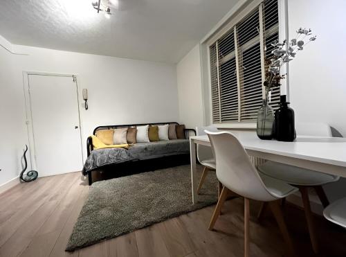 - un salon avec une table, des chaises et un lit dans l'établissement Great 1 bed flat London/Chiswick, à Londres