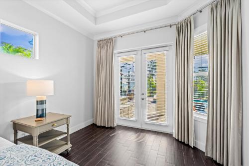 ein Schlafzimmer mit einem Bett und einem Tisch und Fenstern in der Unterkunft Mi aMora a Bonita Retreat in Bonita Springs