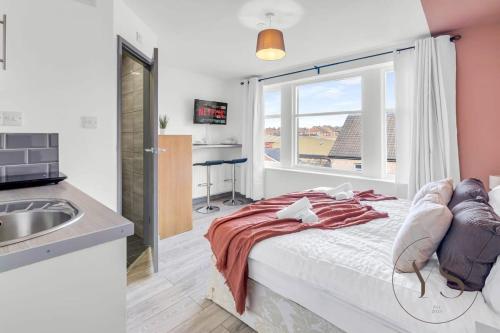 a bedroom with a bed and a sink and a window at Gorgeous Longton Studio 1d in Stoke on Trent