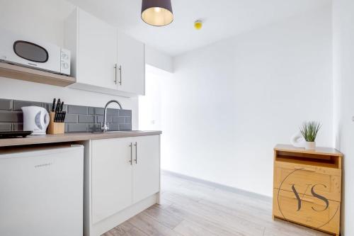 a kitchen with white cabinets and a counter top at Sienna Studio 1E Near Alton Towers with Free Wi-Fi and Netflix Access in Stoke on Trent