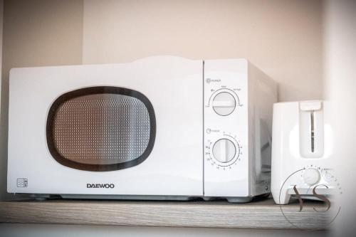 a microwave and a toaster oven sitting on a shelf at Sienna Studio 1E Near Alton Towers with Free Wi-Fi and Netflix Access in Stoke on Trent