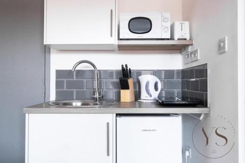 a kitchen with a sink and a microwave at Bright 2D Studio in Longton Near Alton Towers with Smart TV and Self Check-In in Stoke on Trent
