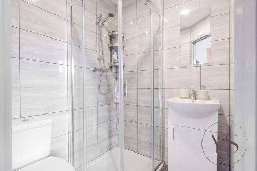 a white bathroom with a shower and a sink at Bright 2D Studio in Longton Near Alton Towers with Smart TV and Self Check-In in Stoke on Trent