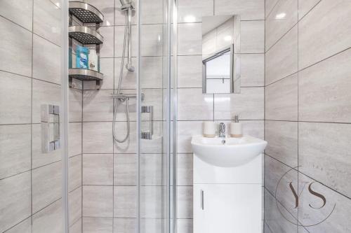 a white bathroom with a sink and a shower at Gorgeous Longton Studio 1a in Stoke on Trent