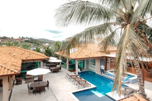 een resort met een zwembad en tafels en stoelen bij Pousada Kanto Suites & Spa in Capitólio