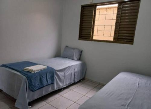 - une chambre avec 2 lits jumeaux et une fenêtre dans l'établissement Casa da Iná! Com piscina e churrasqueira!, à Rio Verde