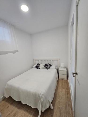 Dormitorio blanco con cama blanca y puerta blanca en MYS Chile27, en Palos de la Frontera