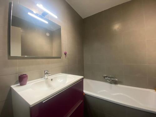 y baño con lavabo, espejo y bañera. en Panorama Lillois, Concierge-City, en La Madeleine
