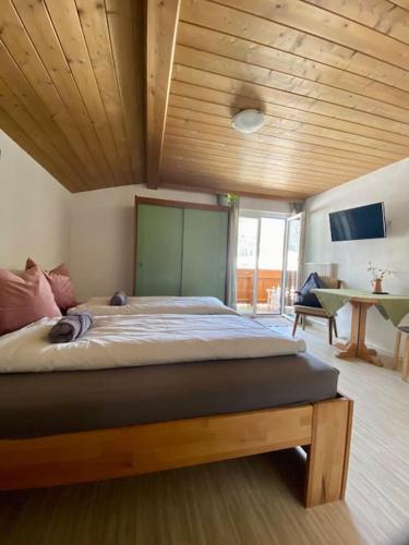 ザンクト・マルティン・アム・テンネンゲビルゲにあるAlpenchalet Basecamp Apartment 2の木製の天井のベッドルーム1室(大型ベッド1台付)