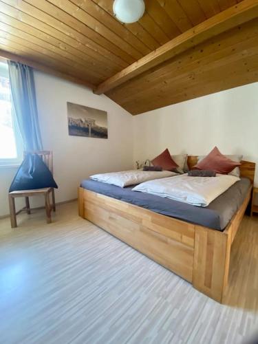 ザンクト・マルティン・アム・テンネンゲビルゲにあるAlpenchalet Basecamp Apartment 2のベッドルーム1室(木製ベッド1台付)