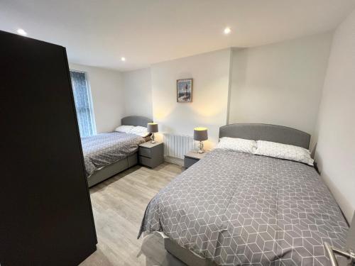 a small bedroom with two beds and a window at El Murrino Apartments in Bournemouth