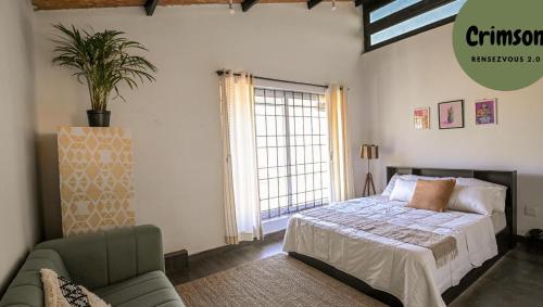 Un dormitorio con una cama y un sofá y una ventana. en Rendezvous, en Coonoor