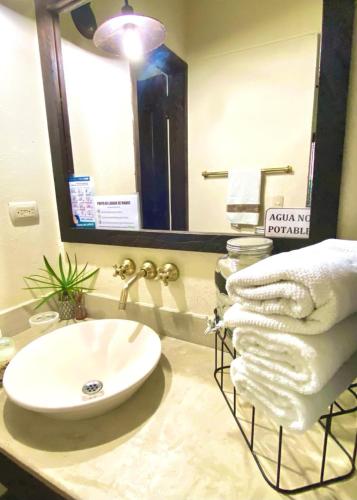 a bathroom with a sink and a mirror and towels at Fincas Panaca Herreria 26 in Quimbaya
