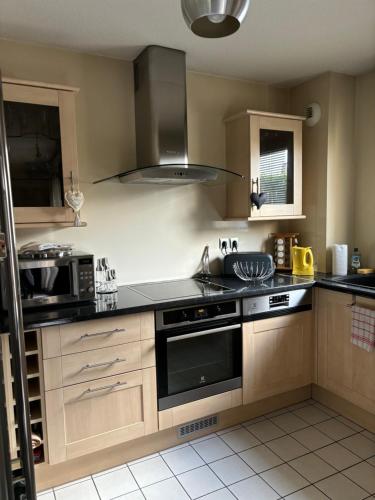 une cuisine avec une cuisinière et un micro-ondes dans l'établissement Appartement T3 4 personnes avec Jardin, à Argenteuil