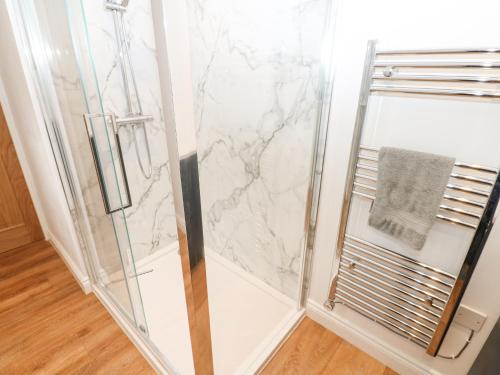 a shower with a glass door with a towel at The Byre in Hexham