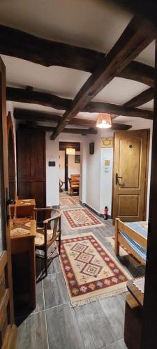 a living room with wooden ceilings and a rug at Golemi kamik Pirot Vlasi 4 in Pirot