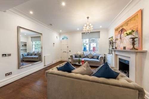 a living room with a couch and a fireplace at Stunning Knightsbridge Townhouse With Patio in London