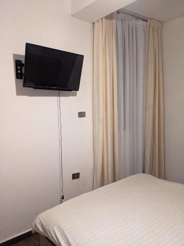 a bedroom with a bed and a flat screen tv on the wall at Casa Feliz - Stylish 2 Bedroom Apartment in Addis Ababa
