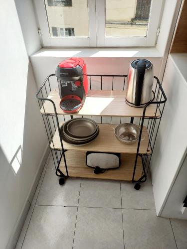 a kitchen cart with appliances on it in a window at T3 rénové en face des Thermes in Néris-les-Bains