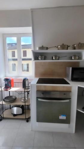 a kitchen with a stove top oven in a room at T3 rénové en face des Thermes in Néris-les-Bains