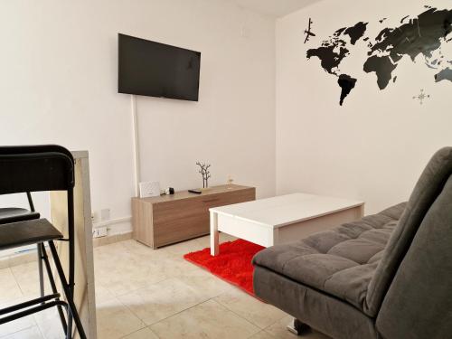 sala de estar con sofá y TV de pantalla plana en Cuore Bernabeu, en Madrid