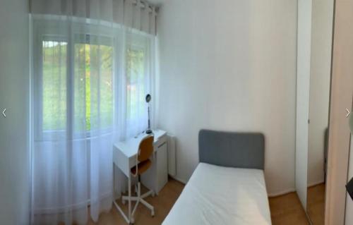 1 dormitorio con cama, escritorio y ventana en Newly renovated ready to welcome you, en Oslo