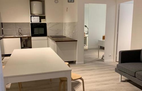 a living room with a white table and a kitchen at Newly renovated ready to welcome you in Oslo