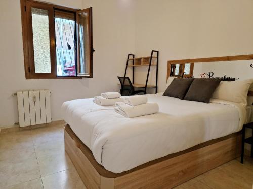 1 dormitorio con 1 cama blanca grande y toallas. en Cuore Bernabeu, en Madrid