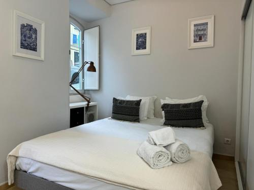 een slaapkamer met een bed met handdoeken erop bij Amazing Apolônia in Lissabon