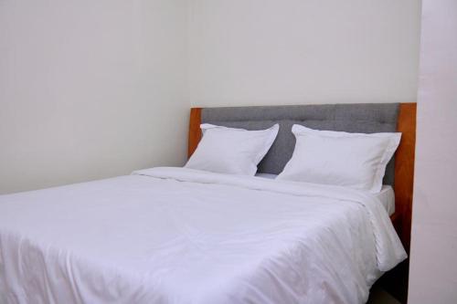 a bedroom with two beds with white sheets and pillows at Woody home bonapriso in Douala