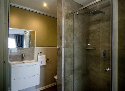 a bathroom with a glass shower with a sink at 6 Dolphin Views La Mercy Beachfront in La Mercy